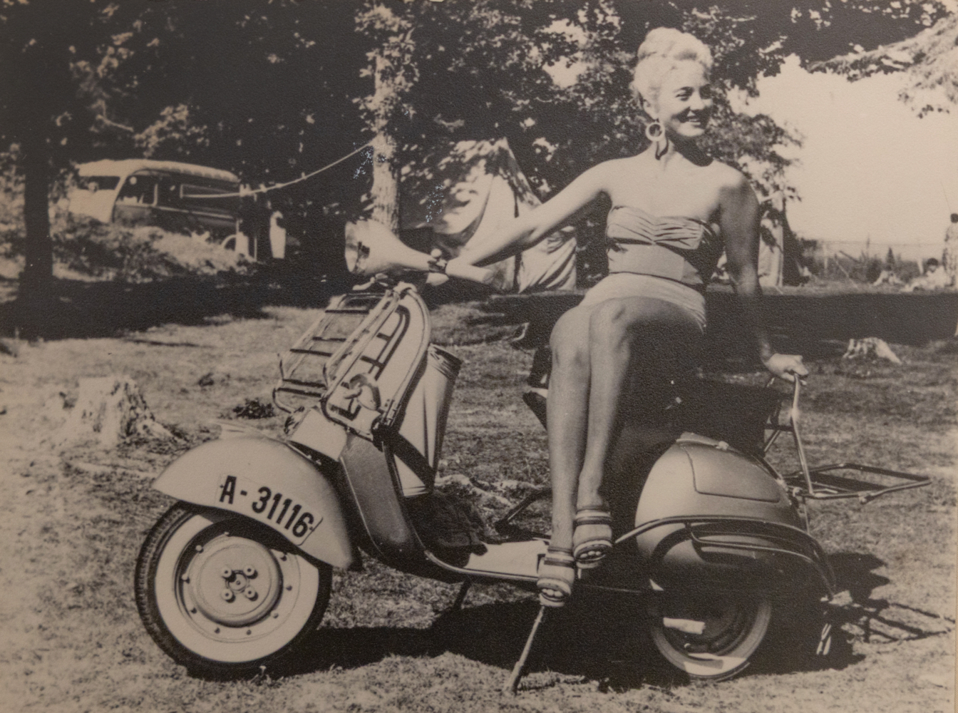 Foto: Gammelt bilde i svart-hvitt av en ung, kvinne på en moped i datidens bikini.