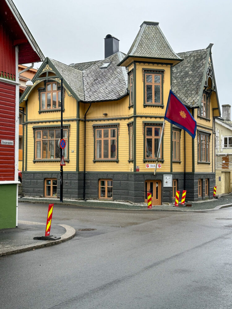 Foto: Av gammel gul trevilla med flagget til Frelsesarmeen på en stang utenfor døra på hjørnet.