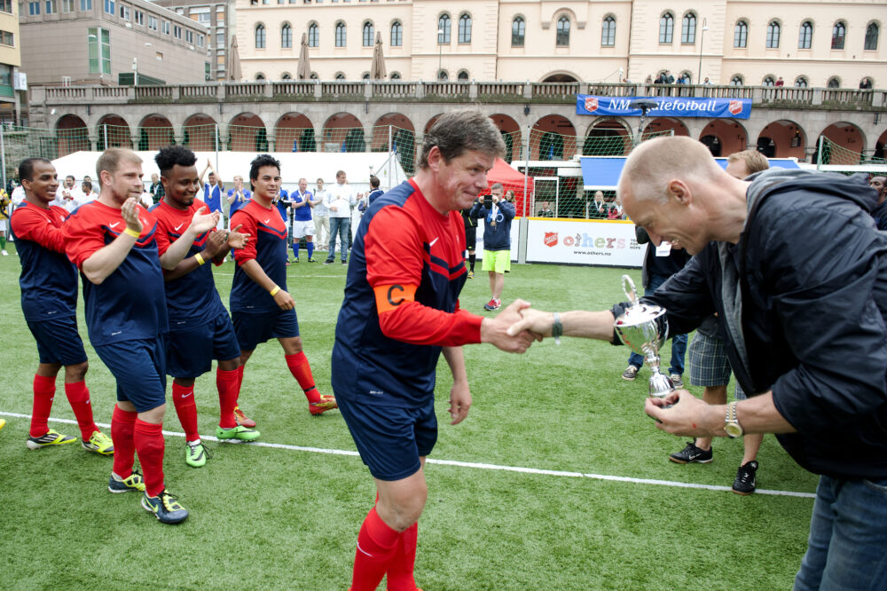 Oslo 27 05 2014 NM i gatefotball pa Youngstorget i Oslo Arrangor Frelsesarmeen Bildet Kaptein pa Friskt Alternativ Stavanger tar i mot beviset pa forsteplassen fra tidligere landslagskeeper Erik Thorstvedt