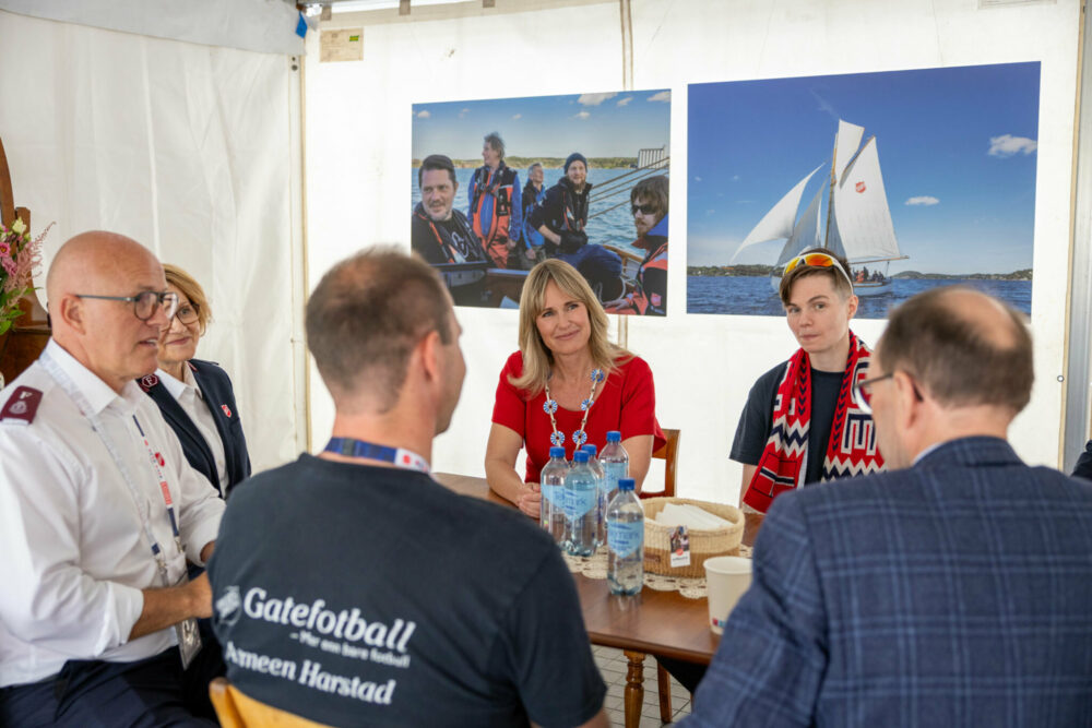 Foto: Seks personer sitter rundt et bor, tre kvinner og tre menn.