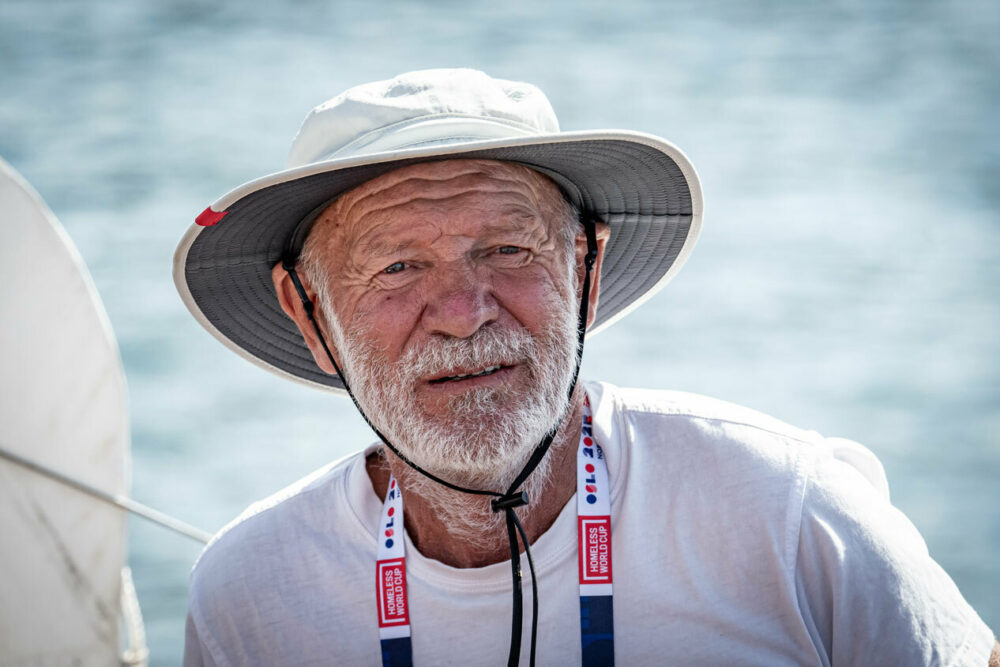 Foto: Eldre mann med grått skjegg hatt sitter i båt.