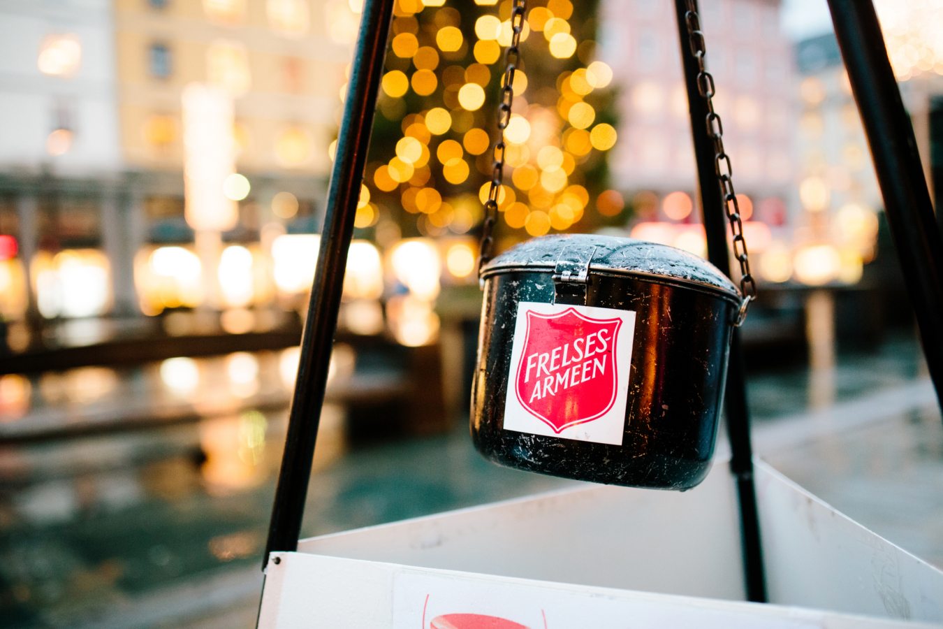 Foto: Bilde av en svart julegryte som henger ned i en kjetting i et stativ. På siden av gryta er det en logo fra FA.