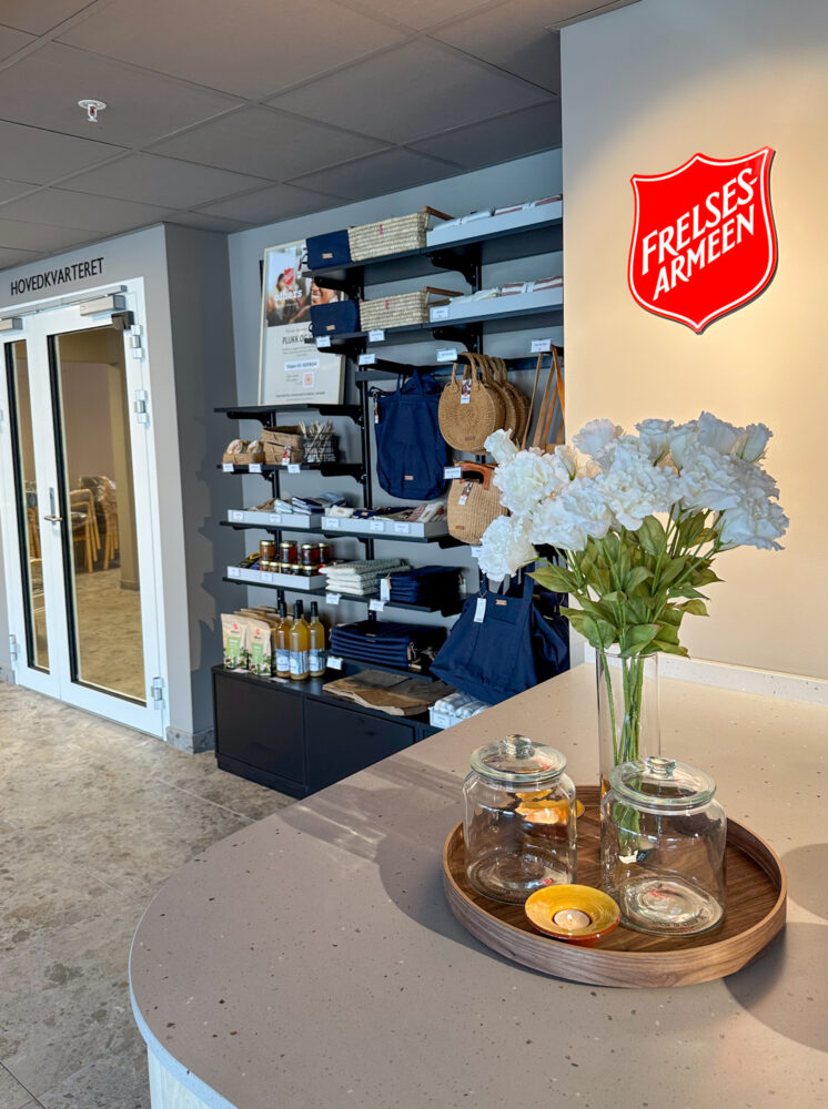 Foto: Bilde fra enden av disken der en ser på hyllene med ting til salgs. Her er også Frelsesarmeens logo stor veggen.