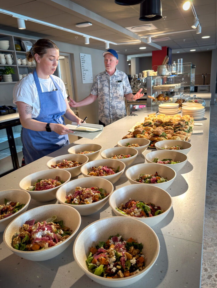 Foto: På en disk står det stilt opp lange rekker med salat i serveringsboller. Bortenfor står fat med focacciaer og ellers bakst.