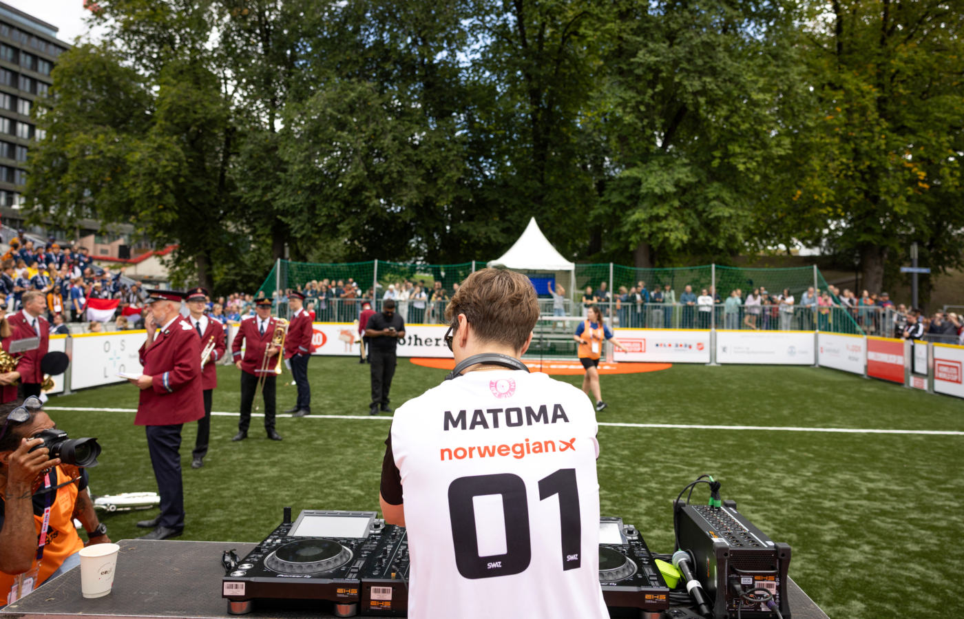 Foto: Mann bak miksepult står med ryggen til fotografen. På den hvite T-skjorta står det MATOMA og tallet 01.