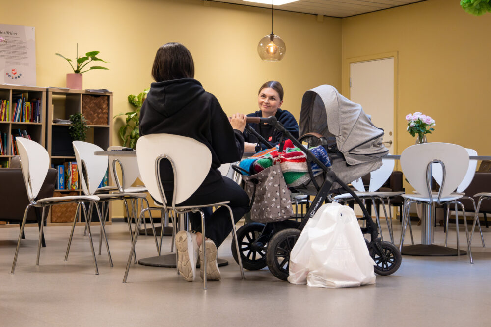 Foto: Mor med barnevogn snakker med representant fra Frelsesarmeen.