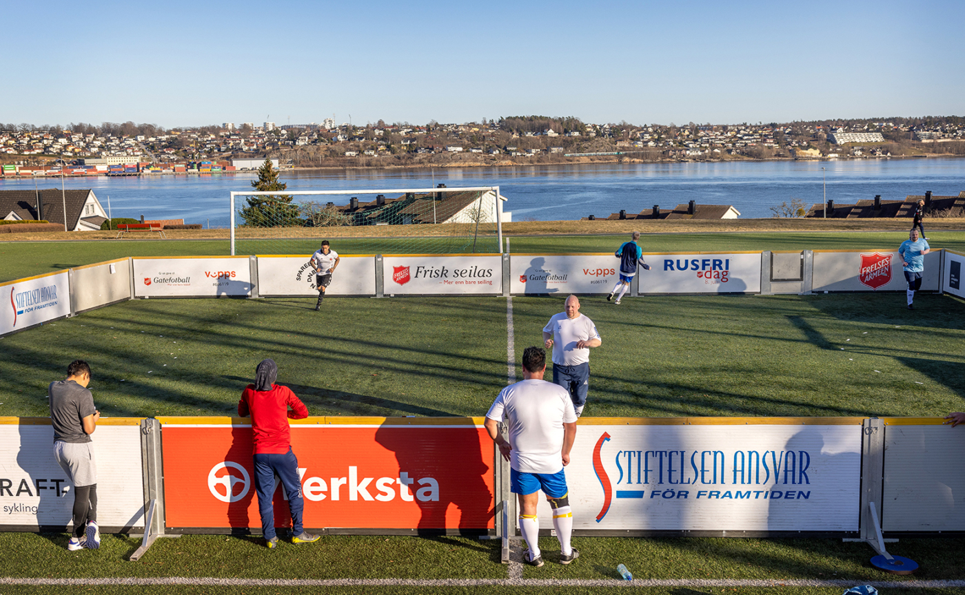 Foto: Flere spillere på en liten bane med sjøen i bakgrunnen.