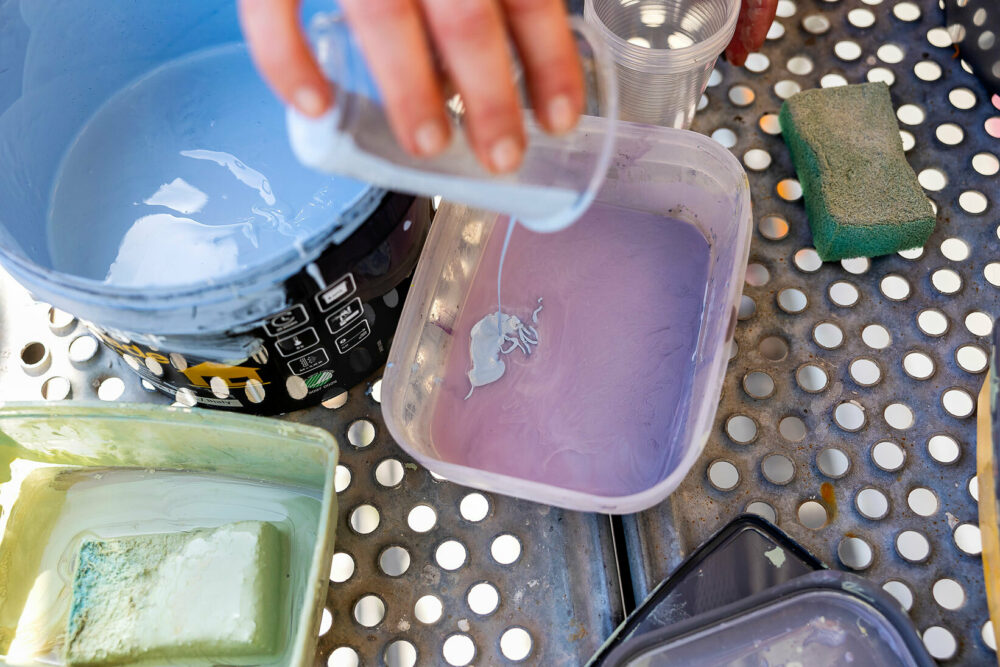 Foto av to bilder, der det første viser blanding av farger i en plastboks og det andre en hånd som påfører maling på veggen med en liten svamp.