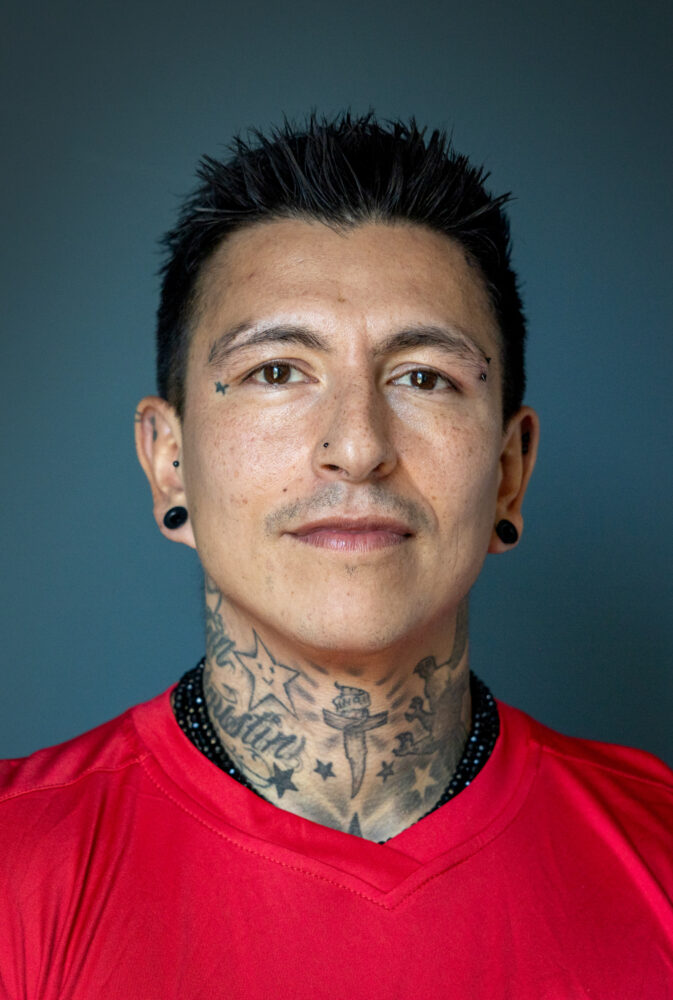 Foto: Mann med gylle hun og kort, svart hår ser alvorlig ut. Han har på seg en rød fotballtrøye.