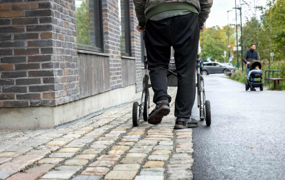 Foto: Bein som går bortover bakover en rullator.