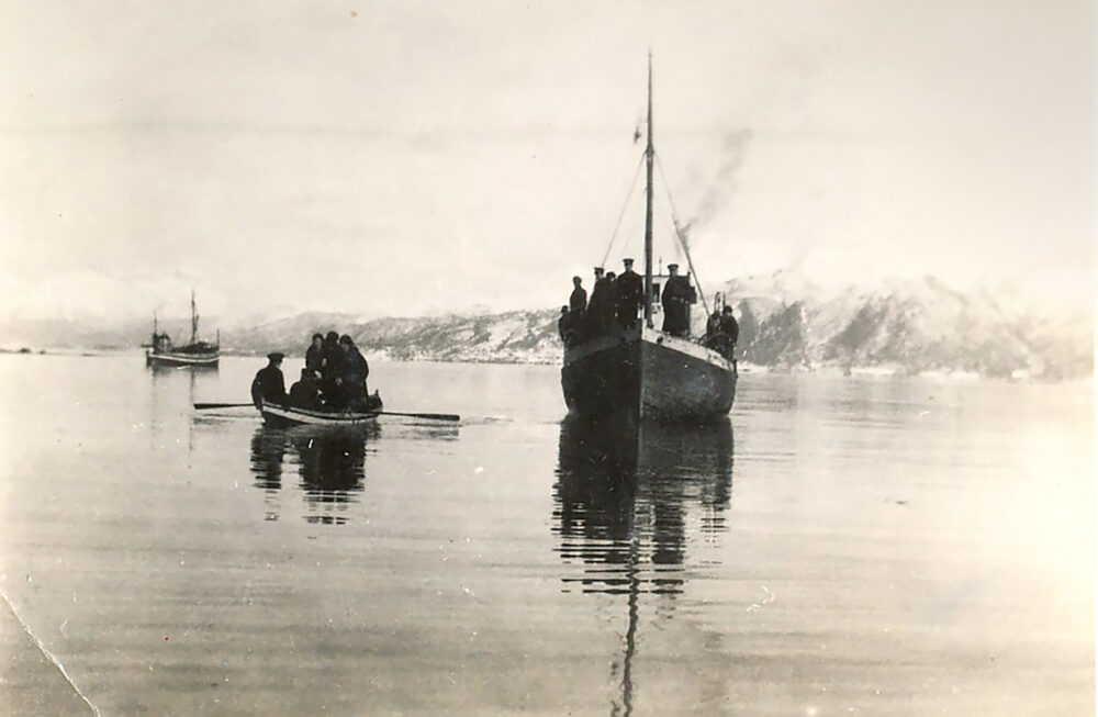 Foto: Gammelt svart-hvitt-bilde med flere båter på sjøen på vei inn mot land.