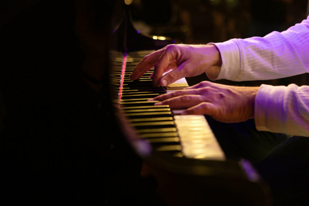 Foto: Hender som spiller på pianotangenter.
