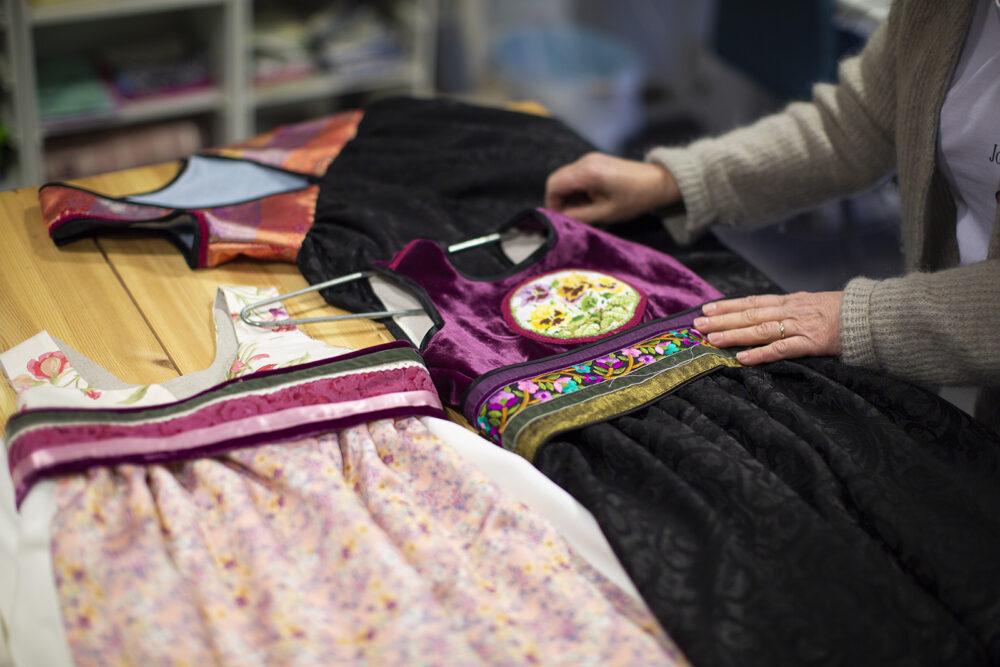 To festdrakter ligger på et bord.