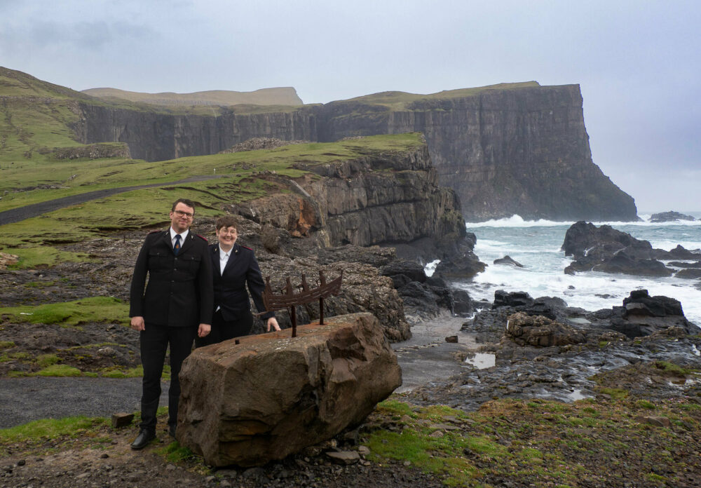 Ektepar i svarte uniformer fra Frelsesarmeen. Rundt dem bar natur og vilt hav.