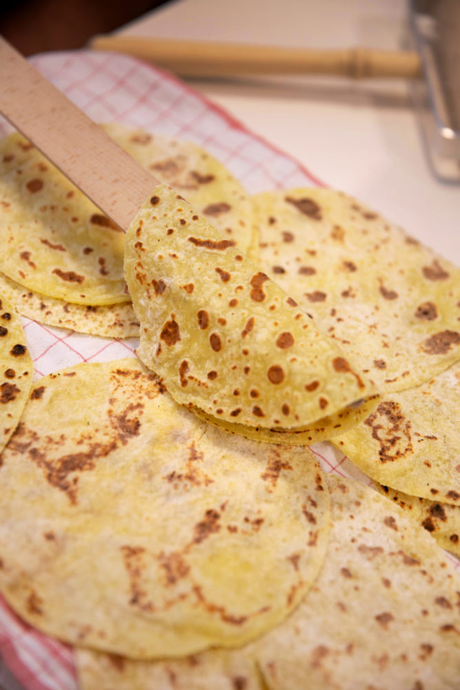 Til venstre: 3 personer står og baker. Til høyre: nærfoto av ei lefse