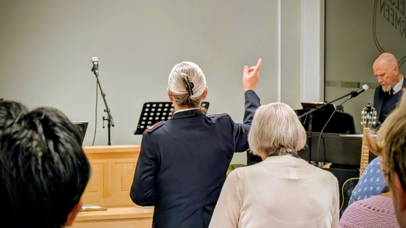 Soldat i Frelsesarmeen løfter hendene i lovsang under Gudstjenesten på Frelsesarmeen i Kragerø